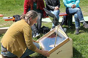 Projektkoordinatorin Andrea Kenk demonstriert die Benutzung der neuen Solaröfen. Bild: Naturpark Südschwarzwald e. V.