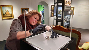 Die Restauratorin Christine Lincke platziert den Kristallpokal in der Ausstellung. Historisches Museum der Pfalz Speyer, Foto: Franziska Hanöffner