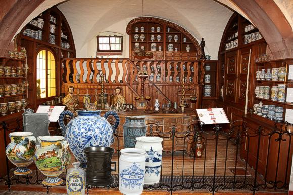 Aufstellung der Sammlung im Deutschen Apotheken-Museum, integriert in das Barock-Mobiliar aus der Hof-Apotheke Bamberg. Im Vordergrund einige besonders bemerkenswerte Stücke der Sammlung. Bild: Deutsches Apothekenmuseum