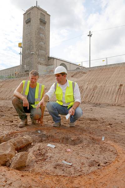 Grabungsleiter Dr. Martin Thoma (links) und Dr. Andreas Thiel, Gebietskonservator und Fachwissenschaftler für Provinzialrömische Archäologie, knien vor einem runden Töpferofen. Bild: © Landesamt für Denkmalpflege
