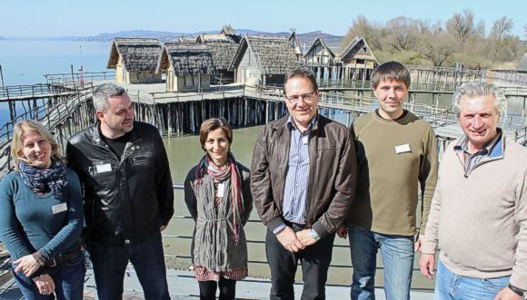 Teilnehmer an der Internationalen Tagung zur Unterwasserarchäologie „In Poseidons Reich XIX“ vor der Kulisse der rekonstruierten Pfahlbauten: (von links) Elena Pranckenaite (Vilnius, Litauen), Igor Miholjek (Leiter des Departments für Unterwasserarchäologie in Kroatien), Antonia Sciancalepore (Forschungszentrum „Lago Bolsena“ in Italien), Gunter Schöbel (Pfahlbaumuseum Unteruhldingen), Segey Olkhovskiy (Archäologisches Institut der Akademie der Wissenschaften, Russische Föderation) und Hanz Günter Martin (Vizedirektor der Deutschen Gesellschaft für Unterwasserarchäologie). © Walter/Pfahlbauten