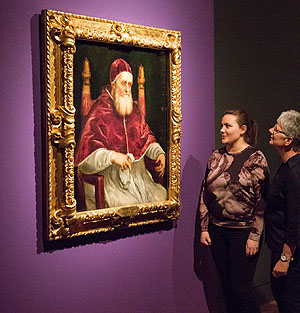 Besucher vor einem Papst-Porträt 