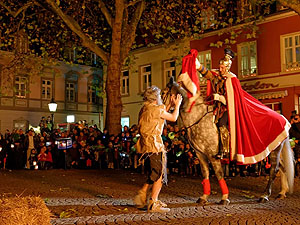 St. Martin, zu Pferd, teilt seinen Mantel mit dem armen Mann.
