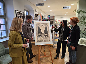 Dr. Barbara Gilsdorf, Lars Maurer, Claudia Freitag-Mair und Jana Garbrecht (v.l.n.r.) begutachten das von Walter Lilie entworfene Werbeplakat für den Schwetzinger Schlossgarten.